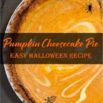 Pumpkin cheesecake pie with swirled orange and cream layers in a graham cracker crust, decorated for a Halloween-themed dessert.