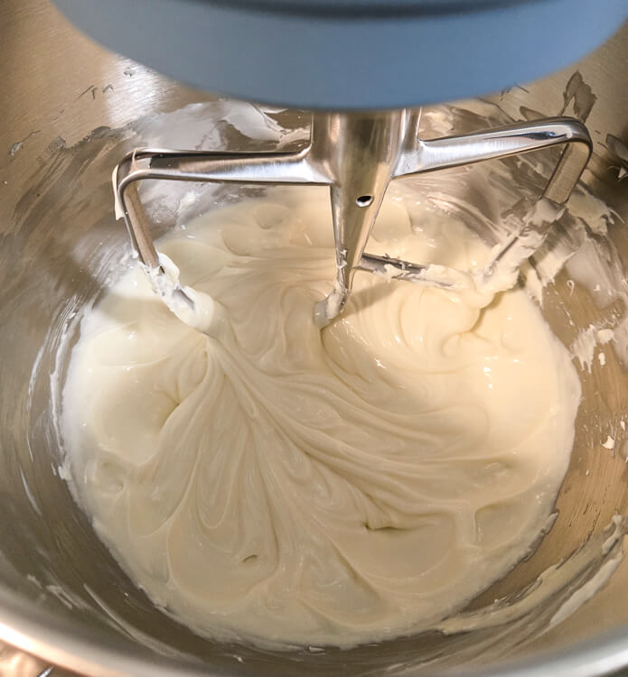 sour cream, cream cheese, and sugar mixed together in a stand mixer