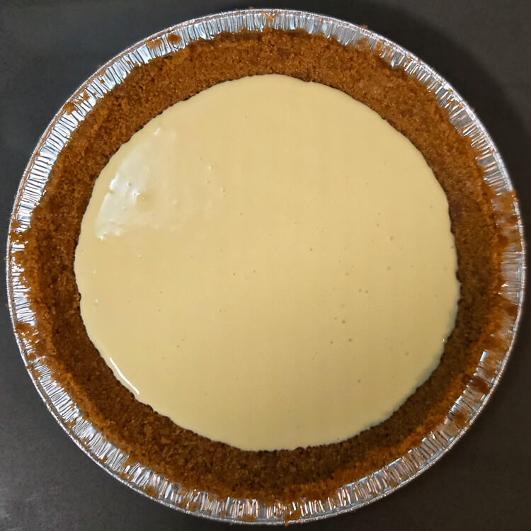vanilla cheesecake filling in a graham cracker crust