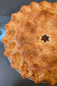 a close up overhead photo of half of a double-crusted pie with a star cutout in the center