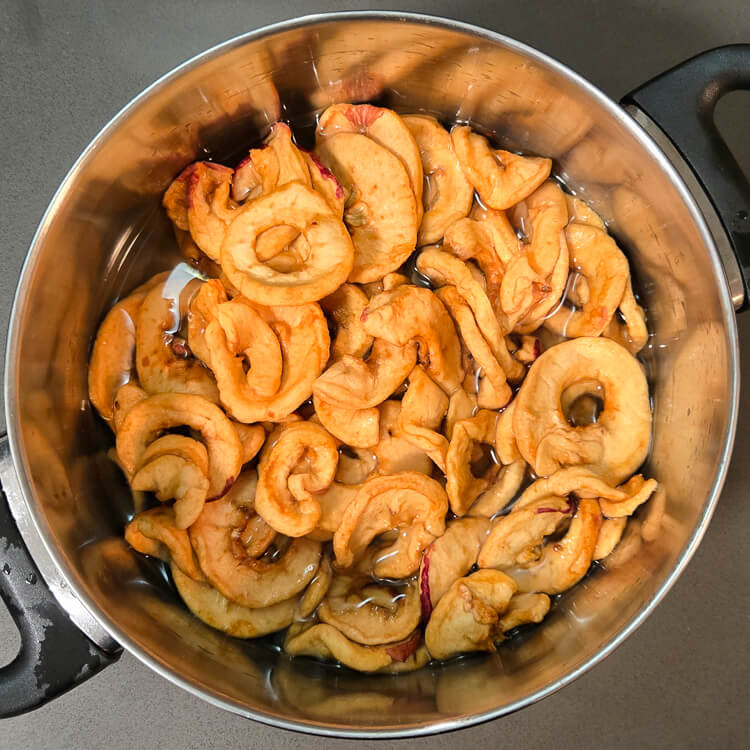 overhead photos of dried apple rings being rehydrated in a pot of water