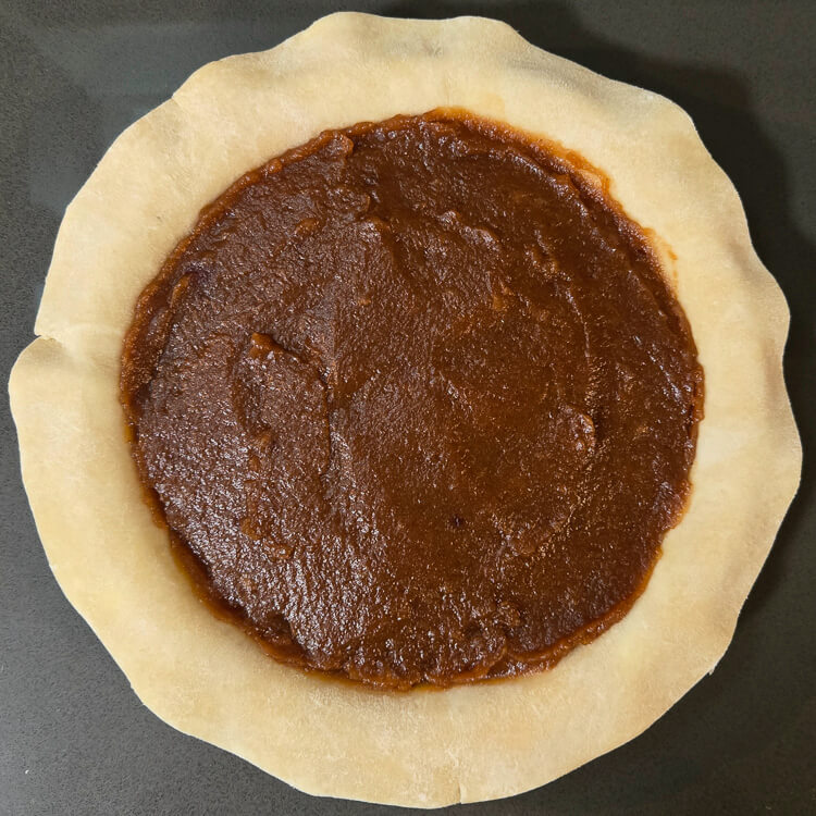 Schnitz pie filling inside of a pie crust