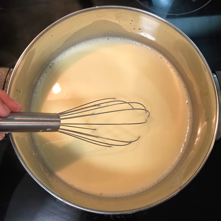 an overhead photo of mixing homemade vanilla pudding on a stovetop