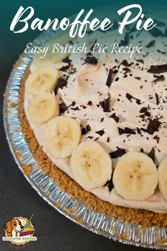 Close-up of a classic British banoffee pie topped with whipped cream, sliced bananas, and chocolate shavings in a crumb crust.