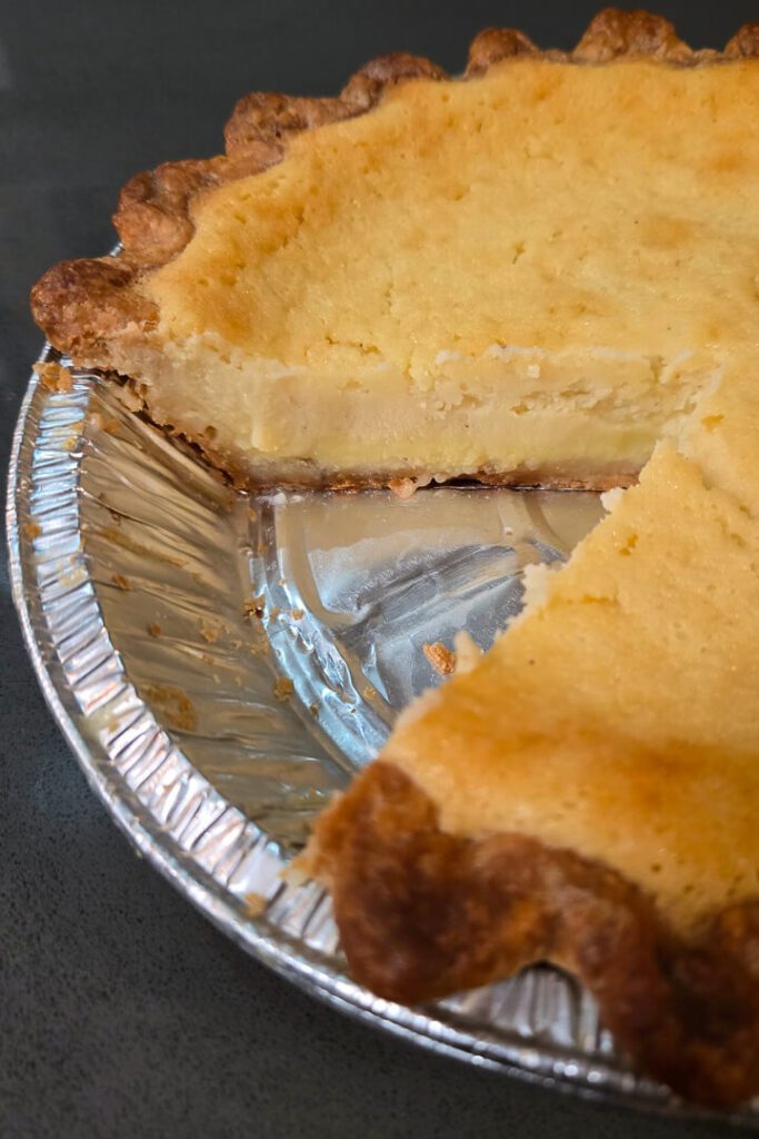 a close up photo of a cross-section of buttermilk pie with a slice cut out