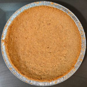 overhead photo of a baked, golden brown crumb pie crust made with digestive biscuits