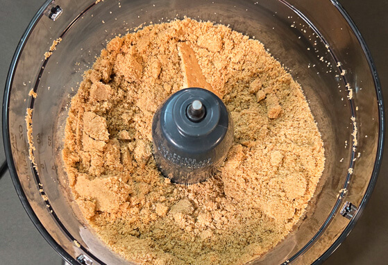 overhead photo showing crackers ground down into crumbs in a food processor
