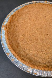 overhead close up photo of a golden brown digestive biscuit pie crust for banoffee pie