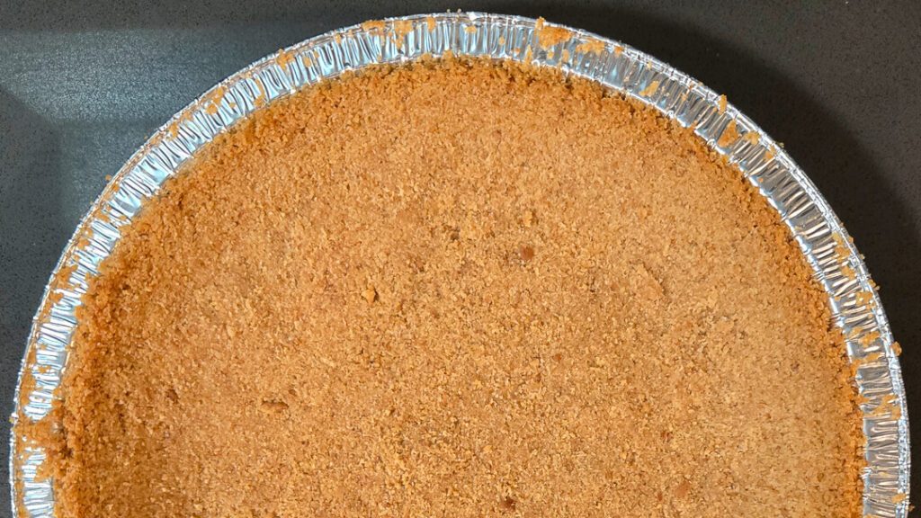 overhead photo of half of a crumb crust for a pie made with digestive biscuits as a substitute for graham crackers or as a crust for banoffee pie
