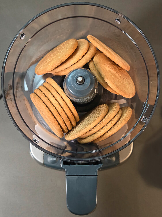 overhead photo of digestive biscuits in a food processor to turn into crumbs for a pie crust