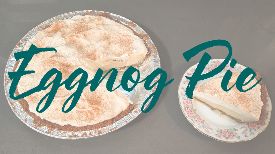 an overhead photo of an eggnog cream pie with a slice cut out and placed on a plate next to it with text overlay that reads "Eggnog Pie" for Eggnog cream pie