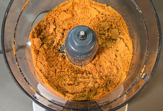 overhead photo of gingerbread cookies ground into gingerbread crumbs in a food processor