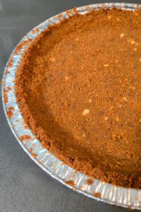 close up photo of a gingerbread pie crust in a pie tin