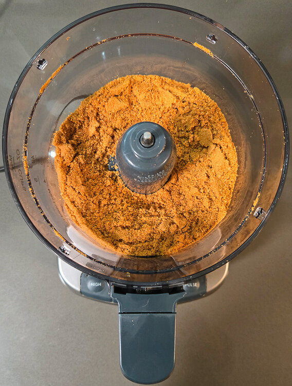 overhead image of gingersnap cookie crumbs in a food processor to make gingersnap pie crust