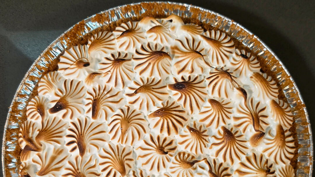 overhead view of half of a piped meringue-topped flapper pie