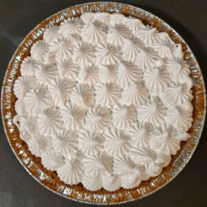 meringue piped on top of a flapper pie before being toasted