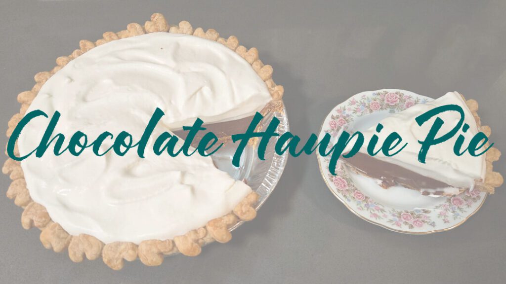 overhead photo of a chocolate haupia pie with a slice cut out and placed next to it on a floral antique plate with text overlay that reads "Chocolate Haupia Pie"