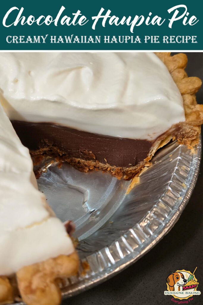 A close up of a chocolate haupia pie with a thick layer of chocolate haupia topped with fluffy whipped cream inside a flaky pie crust, shown with a slice removed to reveal the smooth, glossy chocolate filling.