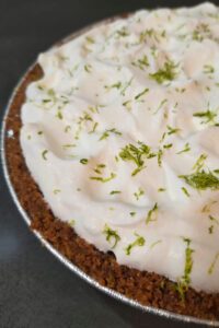 Key lime pie recipe that makes one 9 inch key lime pie baked in a graham cracker crust topped with whipped cream and finished with lime zest