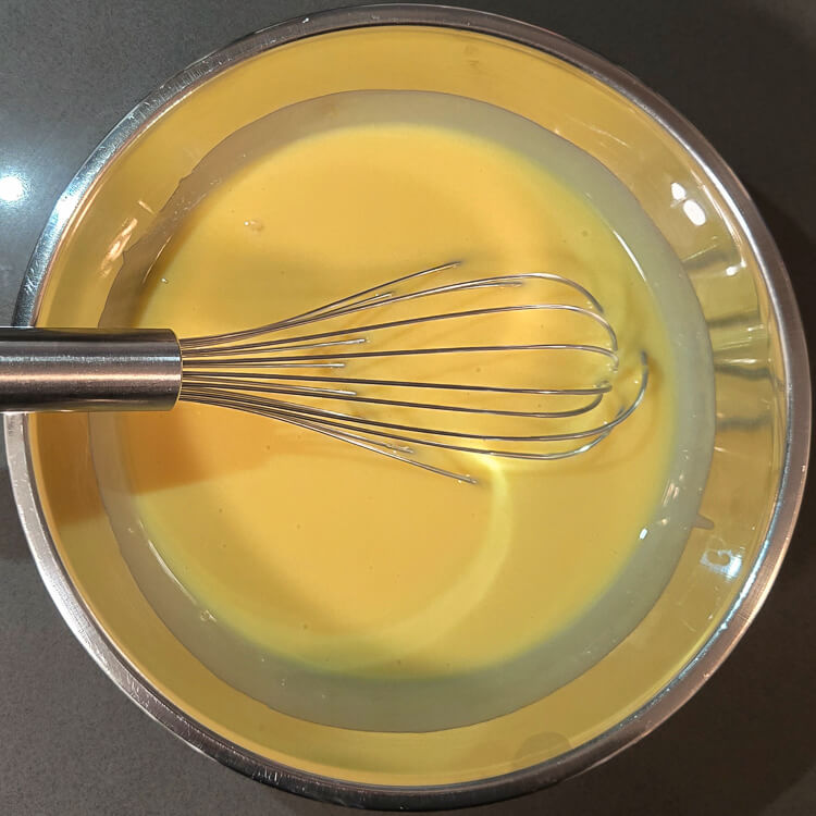 key lime pie filling in a mixing bowl with a metal whisk