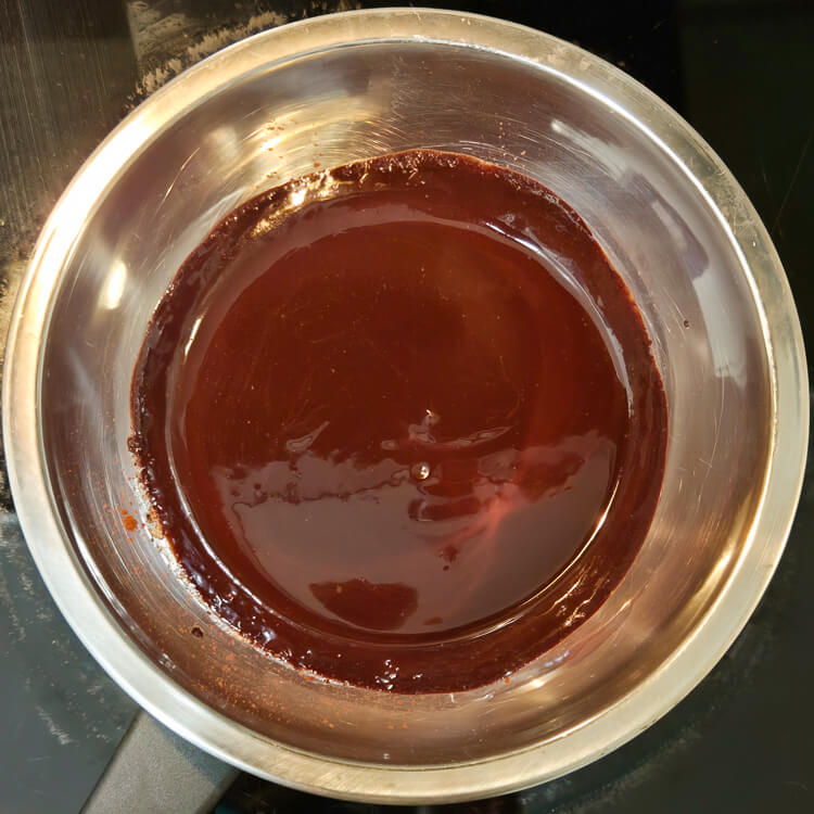 melted chocolate, cocoa powder, and butter on a double boiler on the stovetop