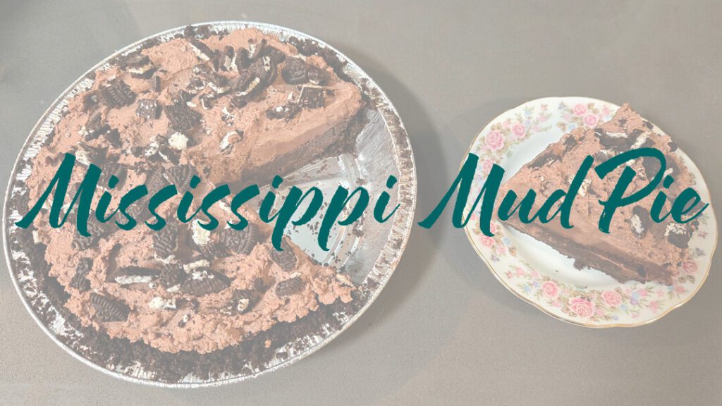Mississippi Mud Pie Recipe header image: a whole Mississippi Mud Pie in a metal pie tin with Oreo crust and crushed Oreo topping with a slice cut out and placed next to it on a floral antique plate with text overlay that reads "Mississippi Mud Pie"