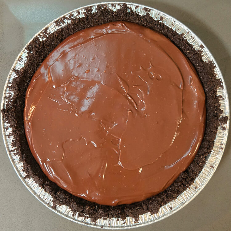 chocolate pudding spread out in an oreo pie crust. Overhead view