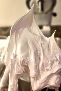 fresh swiss meringue whipped to stiff peaks on a whisk attachment of a stand mixer