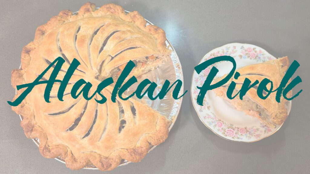 a whole alaskan salmon pie with a slice cut out and placed next to it on a plate with text overlay that reads "Alaskan Pirok"