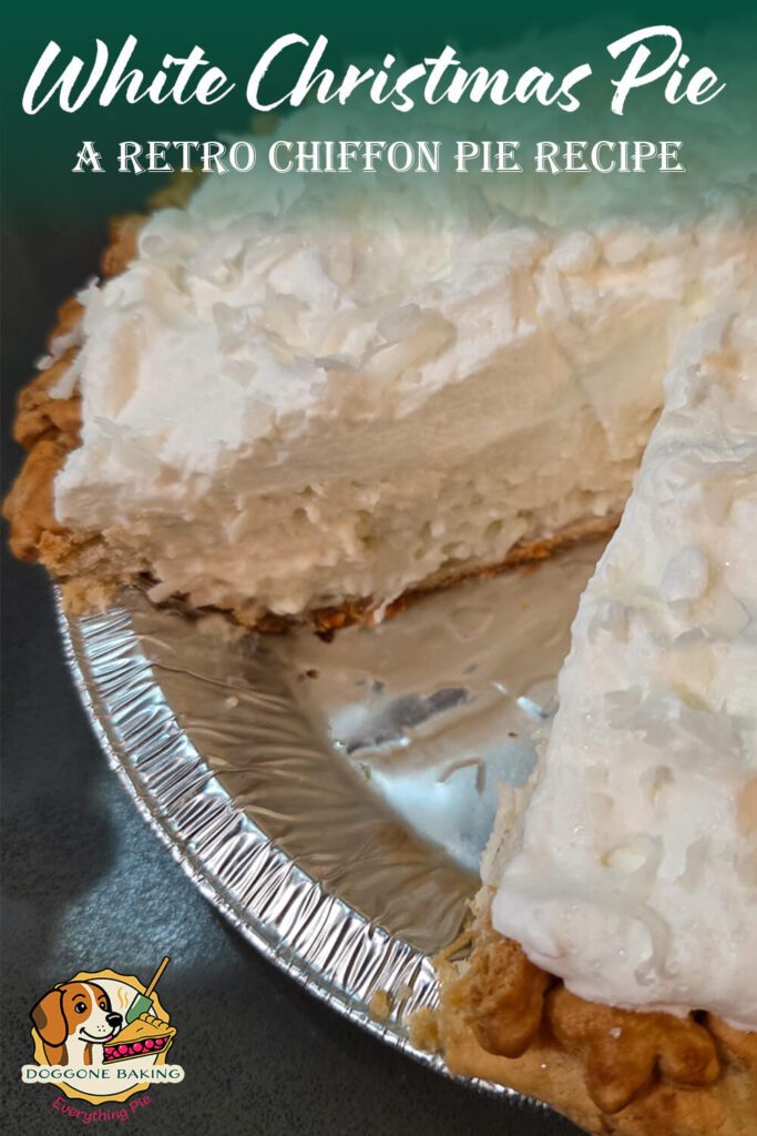 White Christmas chiffon pie in a foil pie pan with one slice missing, showing the fluffy white filling topped with whipped cream and shredded coconut.