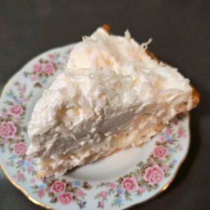 a close up photo of white christmas pie: a chiffon pie flavored with vanilla, almond, and coconut