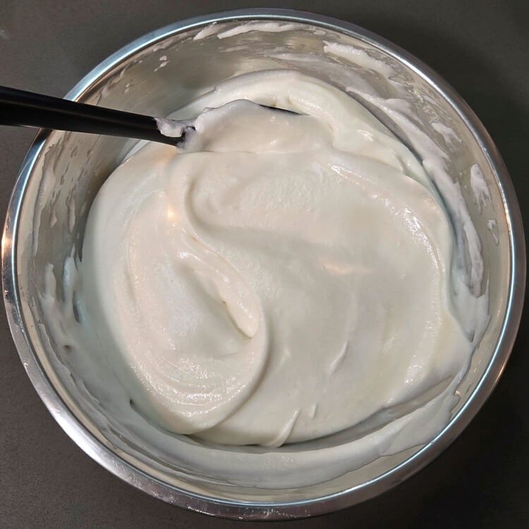 chiffon pie filling being mixed. Folding whipped cream into white christmas pie filling