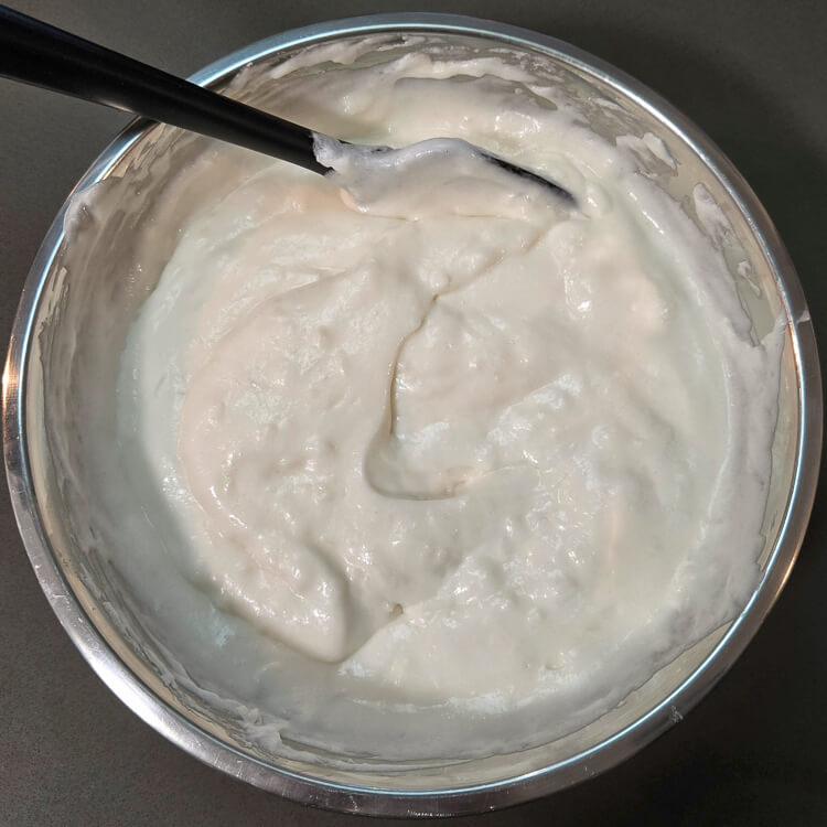 white christmas pie chiffon pie filling after being mixed in a metal mixing bowl before being poured into a pie crust