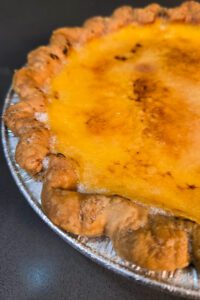 close up photo of a crème brûlée pie with a golden caramel topping
