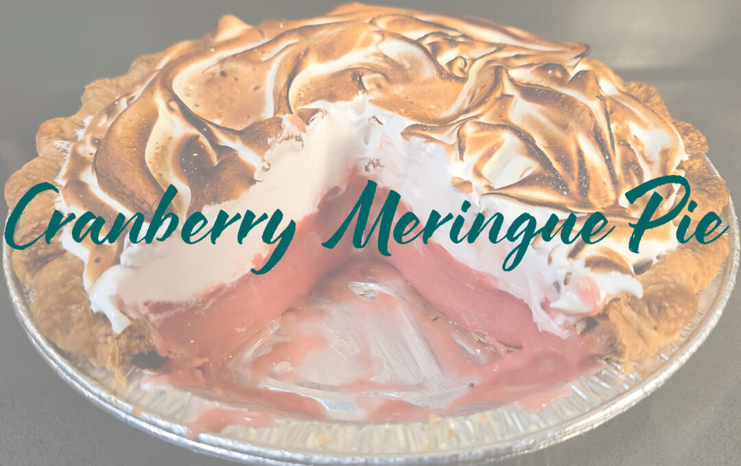 photo of a Cranberry meringue pie with a slice cut out with text overlay that reads "cranberry meringue pie"