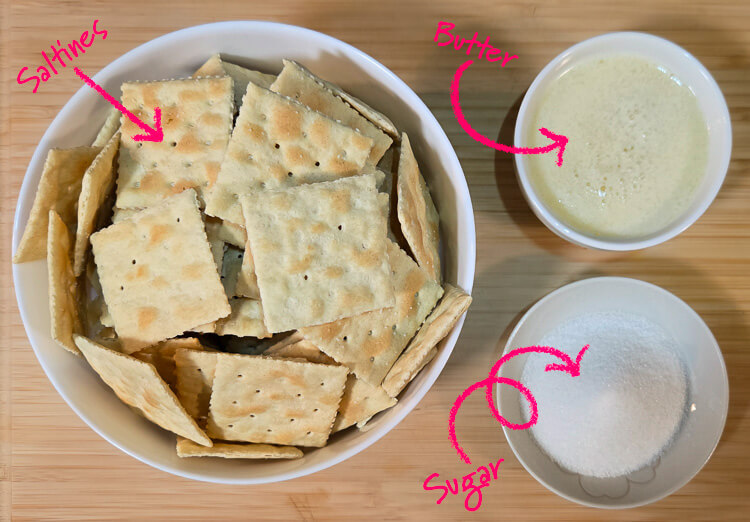 ingredients for a saltine cracker crust laid out on a cutting board with text labels: saltines, butter, and sugar