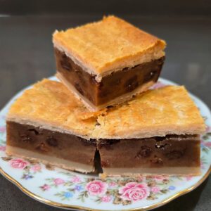 close up photo of 3 pieces of chester cake (gur cake) on a floral plate