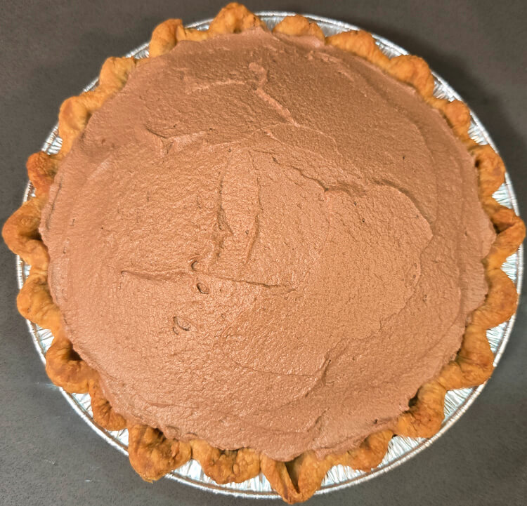 an overhead photo of a French silk pie after being filled with chocolate mousse and smoothed but before adding any patterns