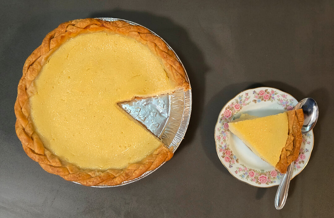 overhead photo of a marlborough pie with a braided crust with a slice cut out, and the slice placed on a plate next to it