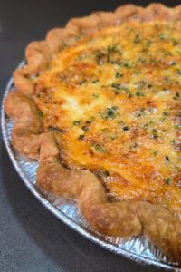 a close up photo of a loaded baked potato quiche