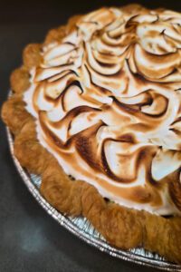 Chocolate Meringue Pie close up photo showing crimped pie crust and toasted meringue