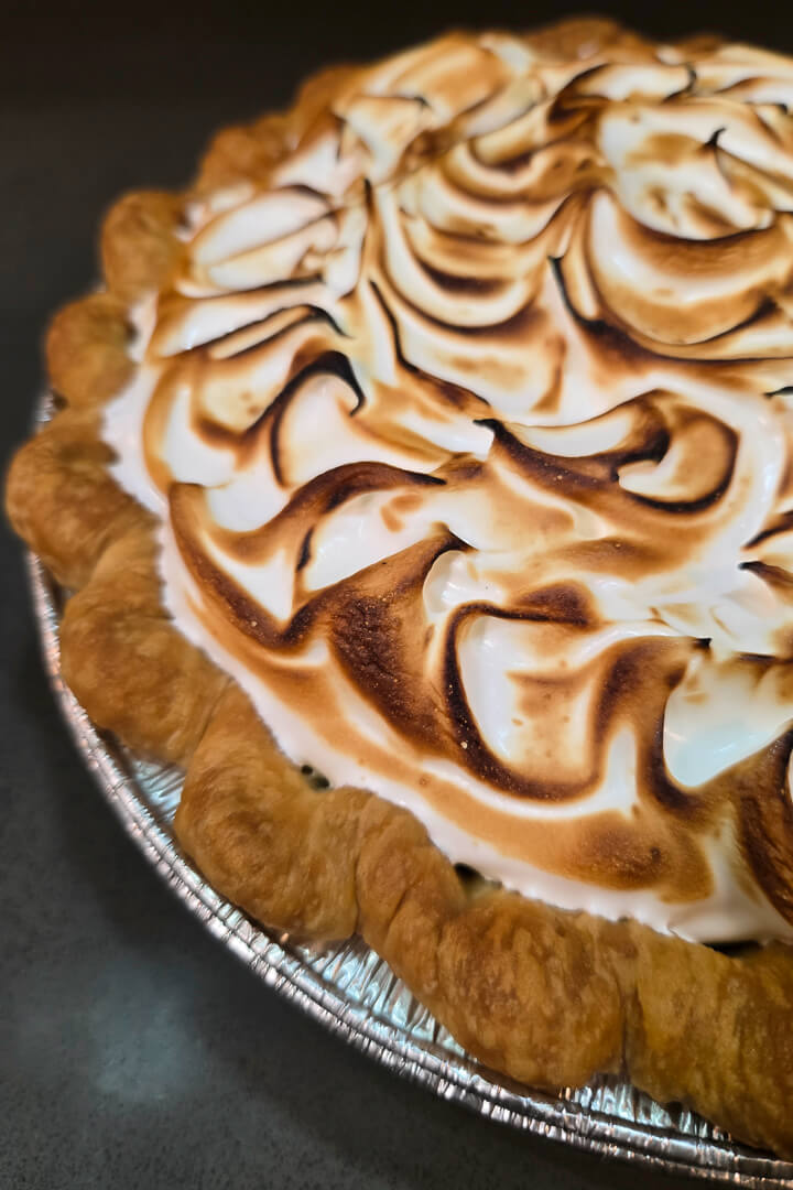 Chocolate Meringue Pie close up photo showing crimped pie crust and toasted meringue