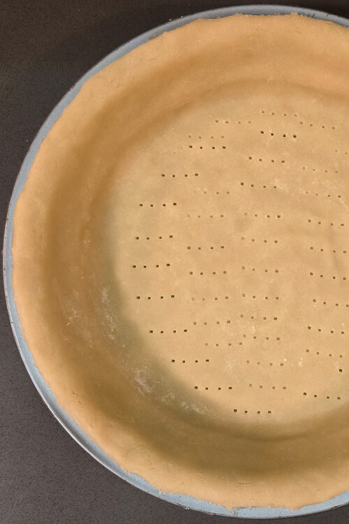 pasta frolla (Italian shortcrust pastry) fitted into a pie tin and docked with a fork to prevent puffing