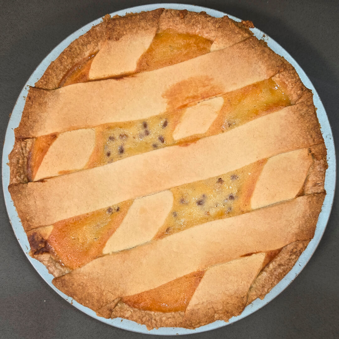 pastiera napoletana: overhead view of the whole pie showing golden filling and lattice made with pasta frolla
