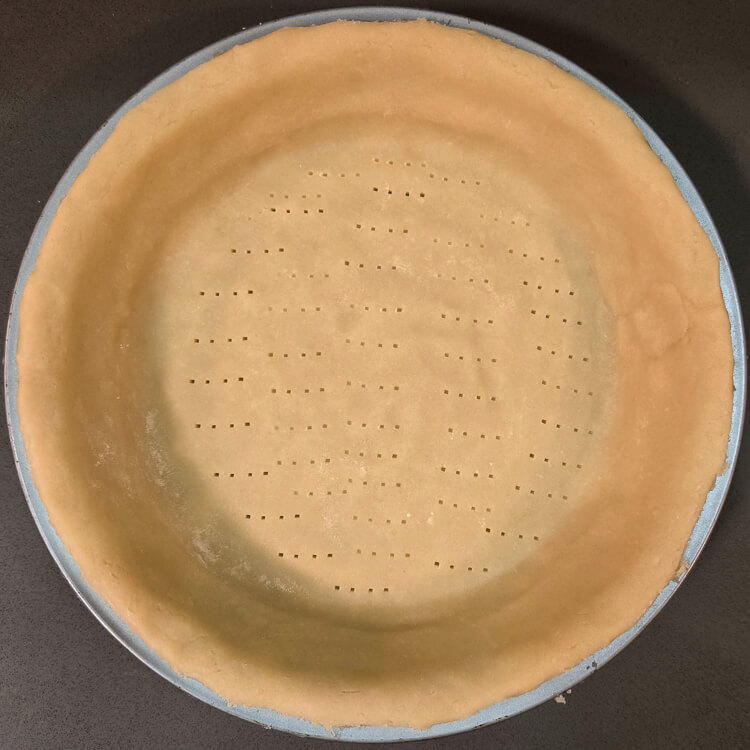 pasta frolla (Italian shortcrust pastry) fitted into a pie tin and docked with a fork to prevent puffing