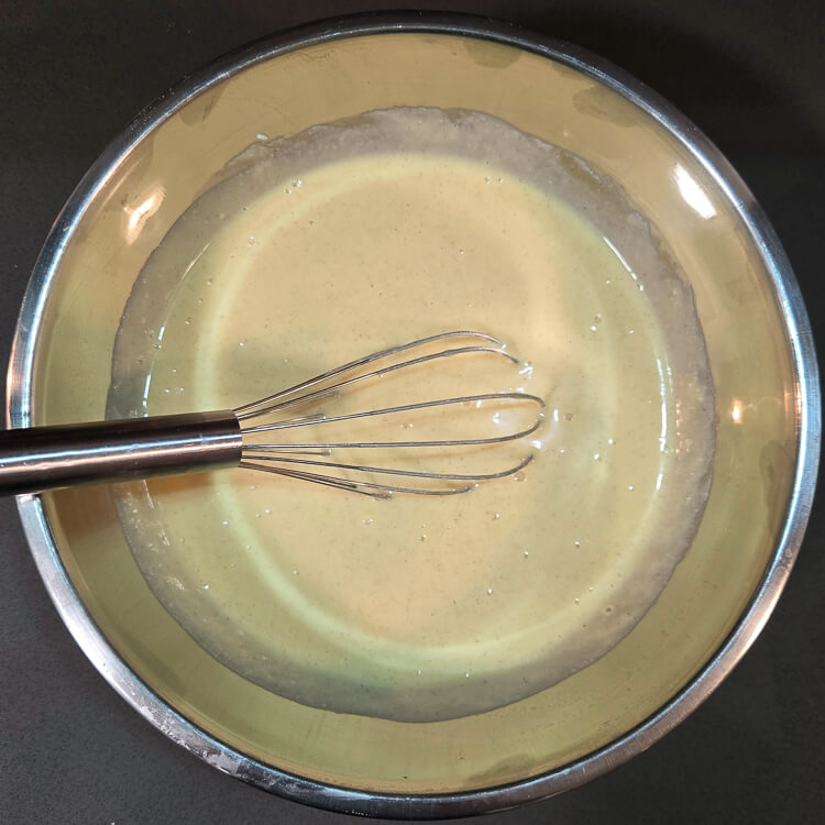 mixing filling for pastiera napoletana in a metal mixing bowl with a metal whisk