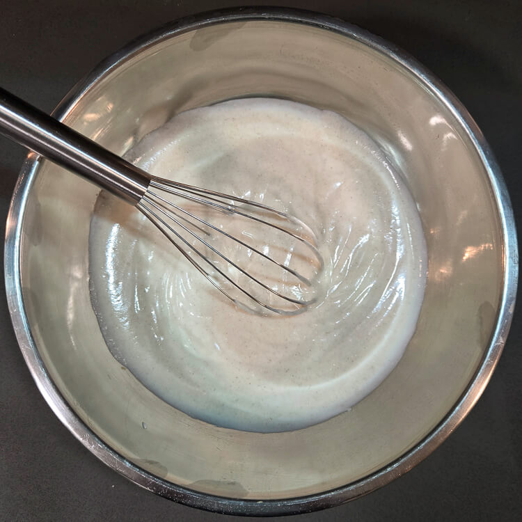 mixing filling for pastiera napoletana in a metal mixing bowl with a metal whisk