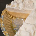 Pinterest pin showing an atlantic beach pie with a saltine crust topped with thick whipped cream and a slice removed revealing a creamy lemon custard filling, with text overlay that reads "Atlantic Beach Pie — An Old Carolina Recipe — Easy Recipe Similar to Key Lime Pie!"