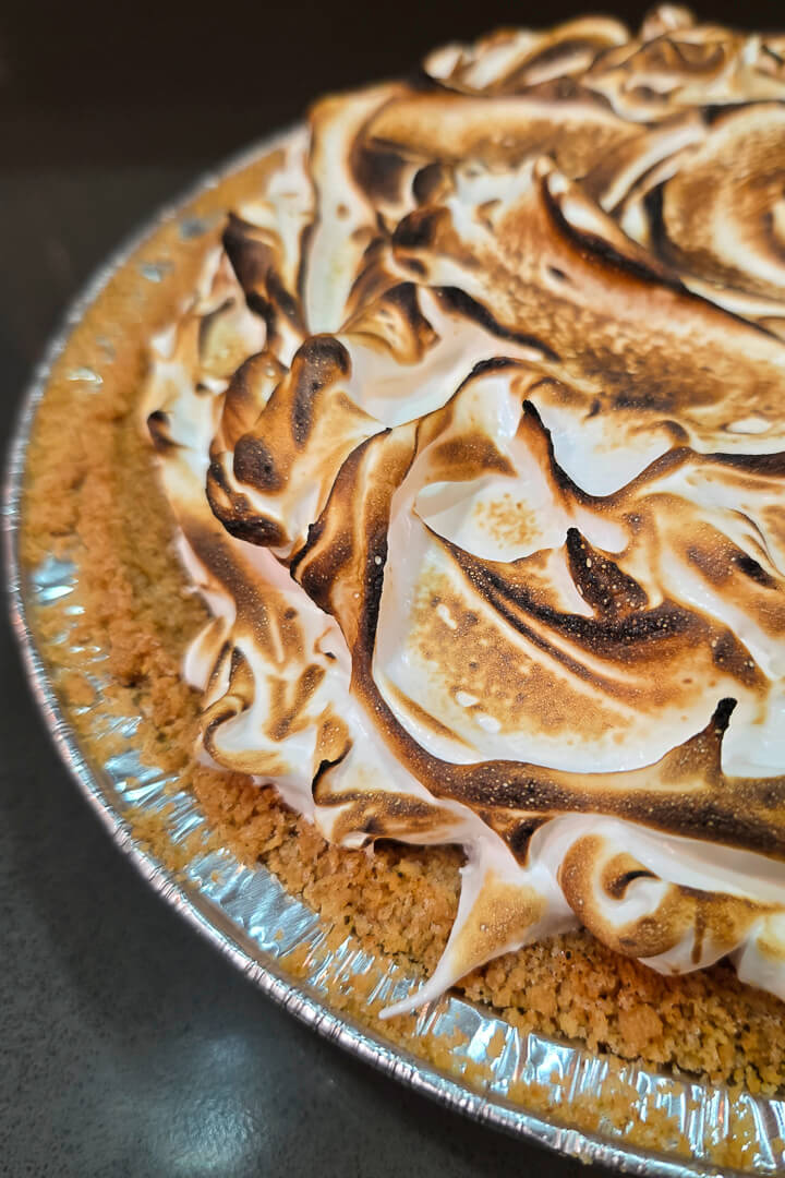S’mores Pie -- toasted marshmallow fluff is spread over the top of a pie in a graham cracker crust