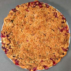 an overhead photo of a whole cherry rhubarb crumble pie